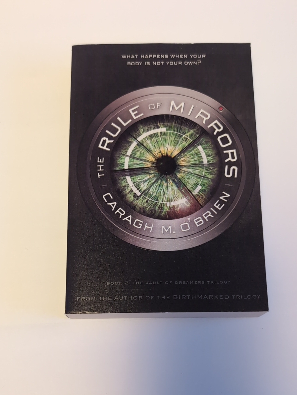 The Rule of Mirrors by Caragh M. O'Brien - Black with Green Eye Cover